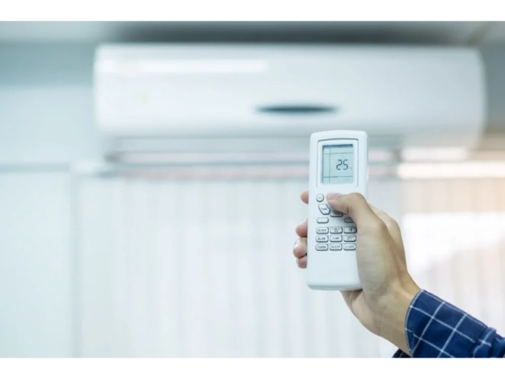hand using remote controller for adjust air conditioner